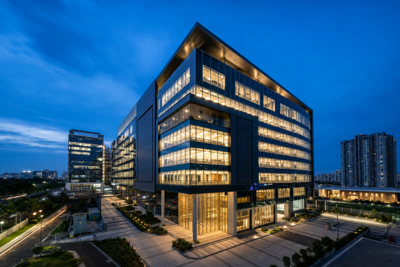 Modern commercial office building with glass facade at dusk