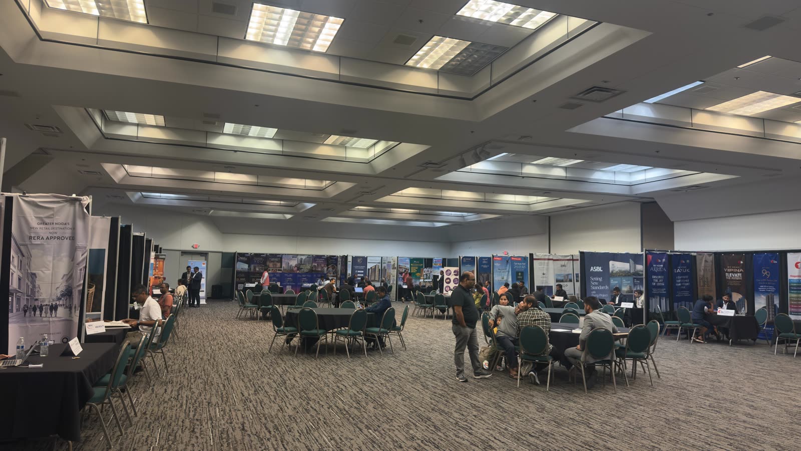 Attendees consulting builder representatives on the Gruhapravesh expo floor